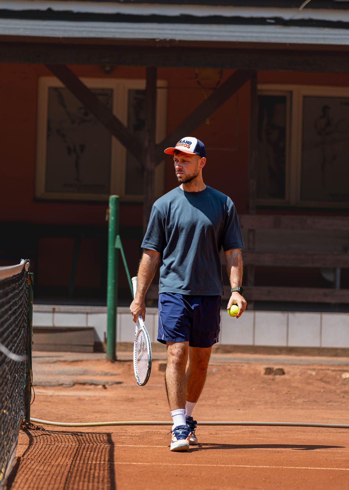 Walking to the baseline with racket and ball