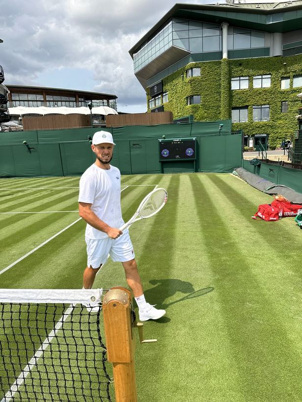 On a Wimbledon practice court in whites