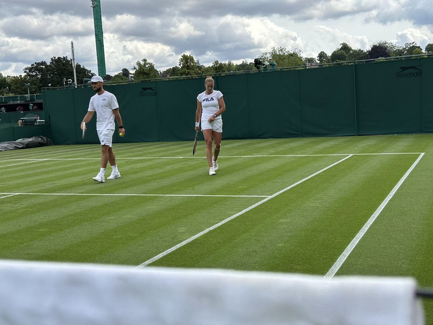 Walking the baseline between drills on a Wimbledon practice court