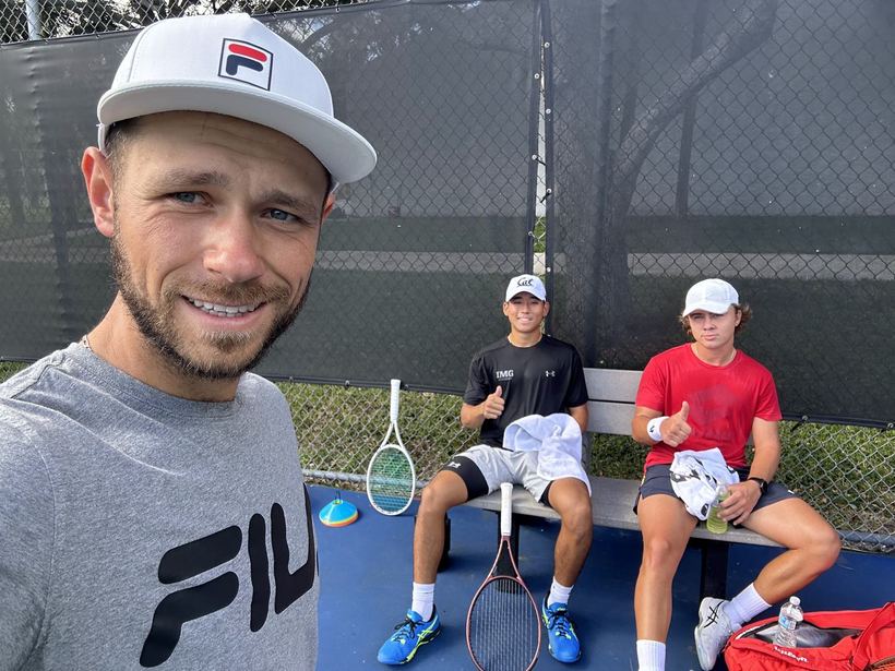 Courtside with two young players after a session